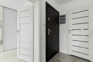 Drei Türen mit unterschiedlichen Designs, eine weiße Wand und ein heller Boden.