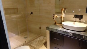 Een douche, handdoeken, zeep, toiletpapier