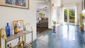 Amplia sala de estar con una mesa de centro de vidrio, un cuadro enmarcado y vistas al balcón exterior.