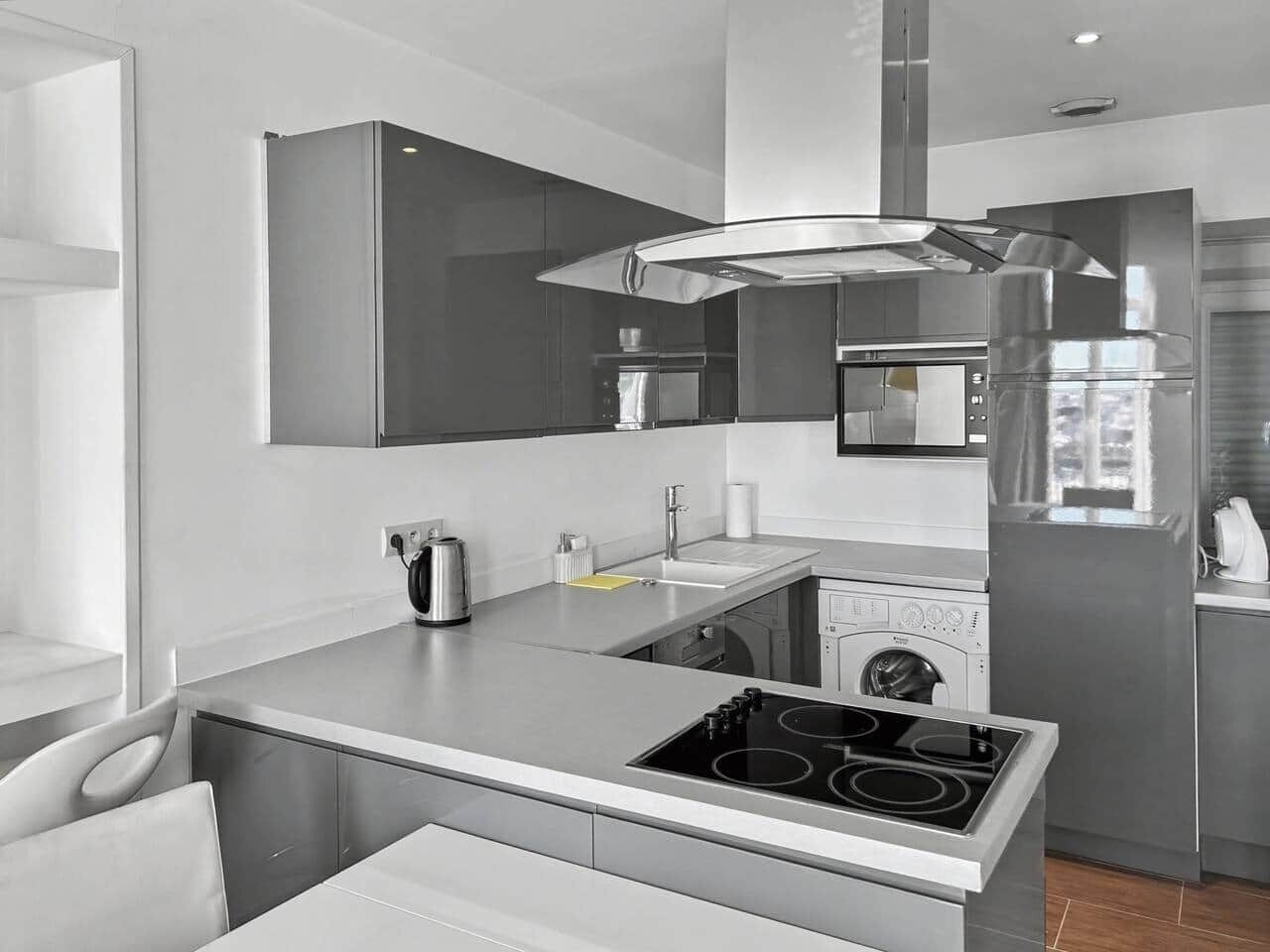 A modern kitchen with a built-in oven, a coffee maker, and a sink.