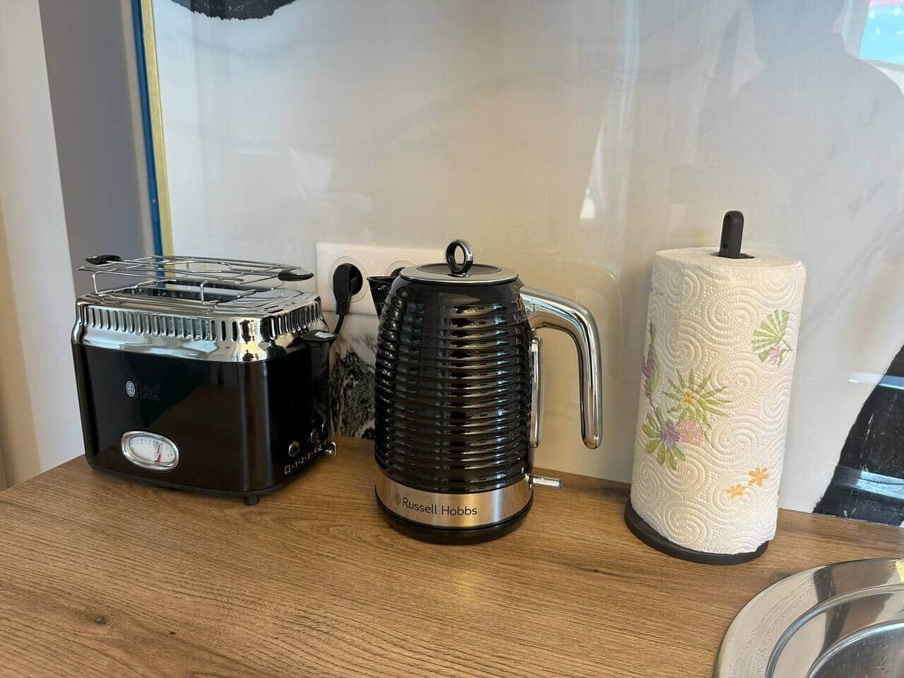 Eine Küchenarbeitsplatte mit einem Toaster, einem Wasserkocher und einer Küchenpapierrolle.