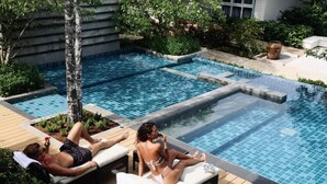 Ein Poolbereich mit Liegestühlen und einem Whirlpool.