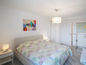 A bedroom with a bed, bedside table, lamp, wardrobe, and a world map on the wall. - Vacation home Canepa by Interhome (Sori)