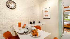 Un plateau de petit-déjeuner avec des croissants, du jus d’orange et une machine à café.