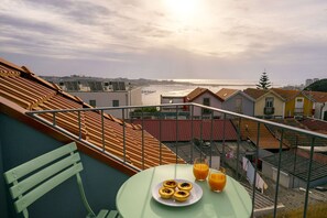 Eine Terrasse mit Tisch, einer Speise und zwei Gläsern Orangensaft.