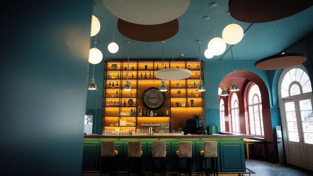 A bar with a counter, shelves with bottles, and a large clock on the wall. - heimatgleis (Brilon)