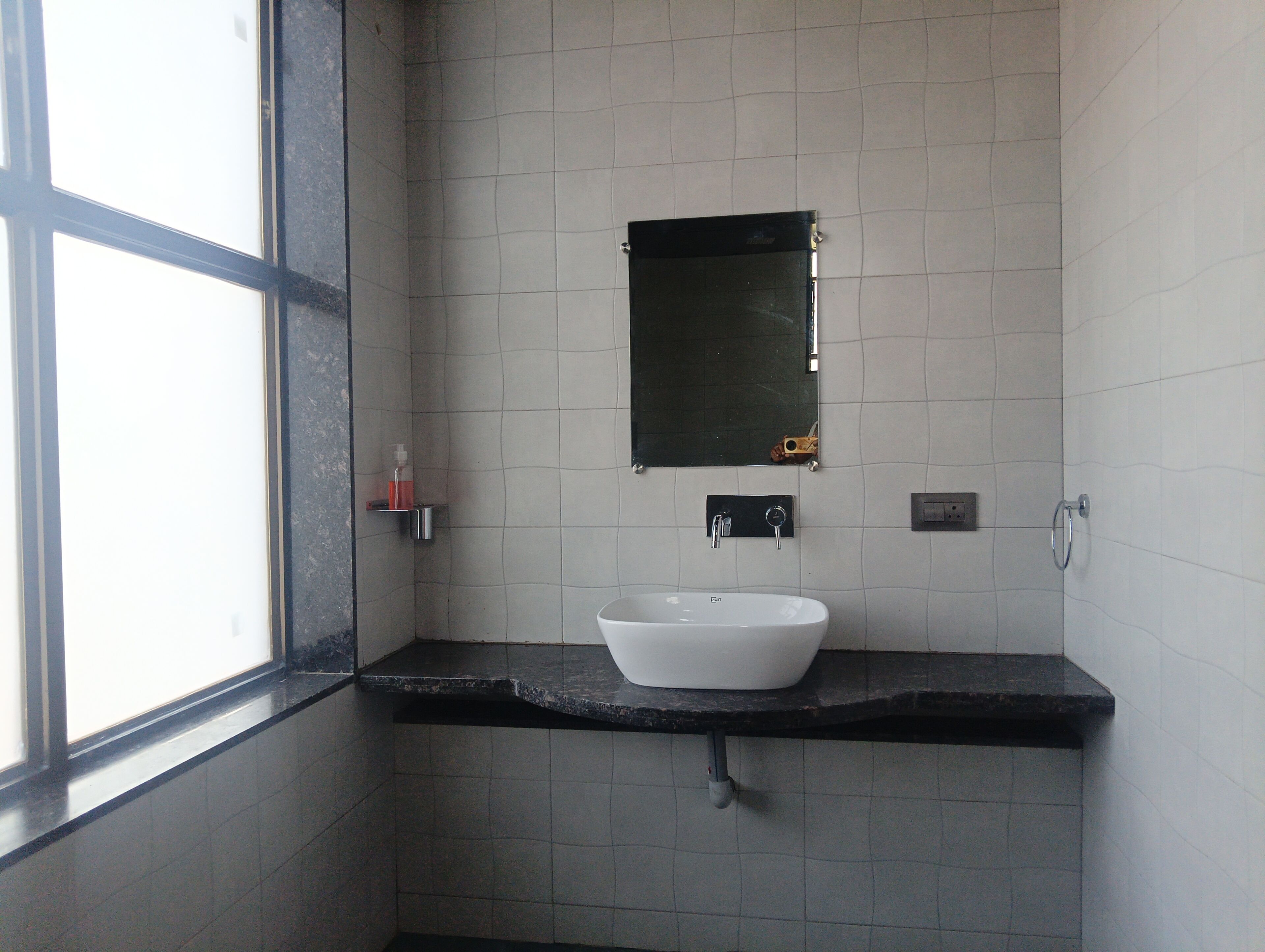 Ein Badezimmer mit Waschbecken, Spiegel und Fenster.