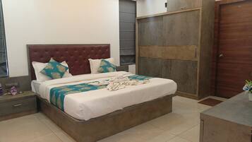 Un dormitorio ordenado con una cama grande, un armario y una mesita de noche.
