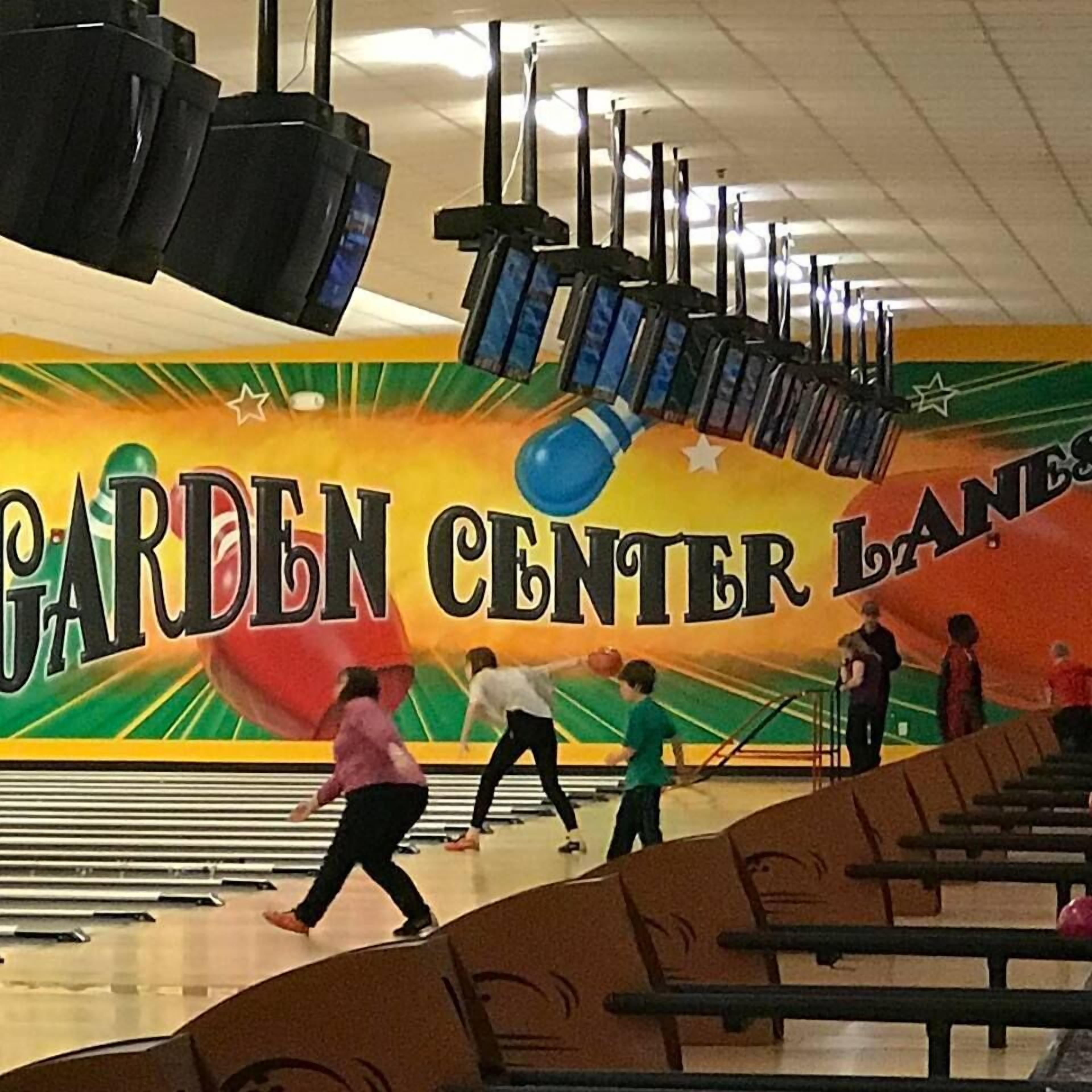 A bowling alley with a colorful mural and multiple lanes.