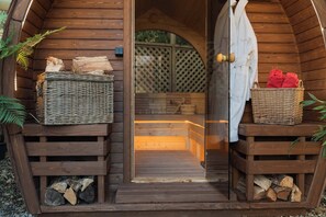 A wooden cabin with a wooden door, a white robe hanging on the door, and two baskets on the steps. - The Old Millhouse Riverside Retreat in Edinburgh (Edinburgh)