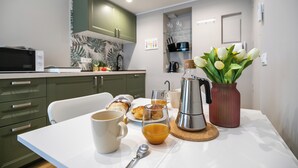 A breakfast setup with croissants, coffee, and tulips on a table. - Italianway Comfort - Sottocorno 17 (Milan)