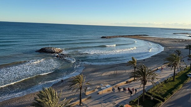 A coastal promenade with a beach, palm trees, and a clear sky. - Cunit Apartment with sea view and balcony (Cunit)