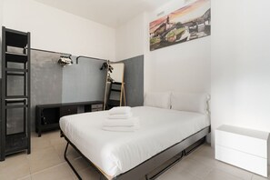 A bedroom with a bed, a desk, a chair, a wardrobe, and a painting on the wall. - Modern 49m2 loft, ideal for 4 people, located in the basement of a building (steps to access).The accommodation is located in the Navigli area, one of the most picturesque areas of the city, with its historic canals and the center of Milanese nightlife.A (Milan)