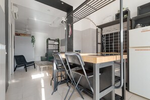 A modern kitchen with a wooden countertop, metal chairs, a hanging rack, and a refrigerator. - Modern 49m2 loft, ideal for 4 people, located in the basement of a building (steps to access).The accommodation is located in the Navigli area, one of the most picturesque areas of the city, with its historic canals and the center of Milanese nightlife.A (Milan)