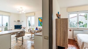 A modern kitchen with a dining area, a large window, and a view of the outdoors. - Sirio Vista Blu Apartment by Interhome (San Lorenzo al Mare)