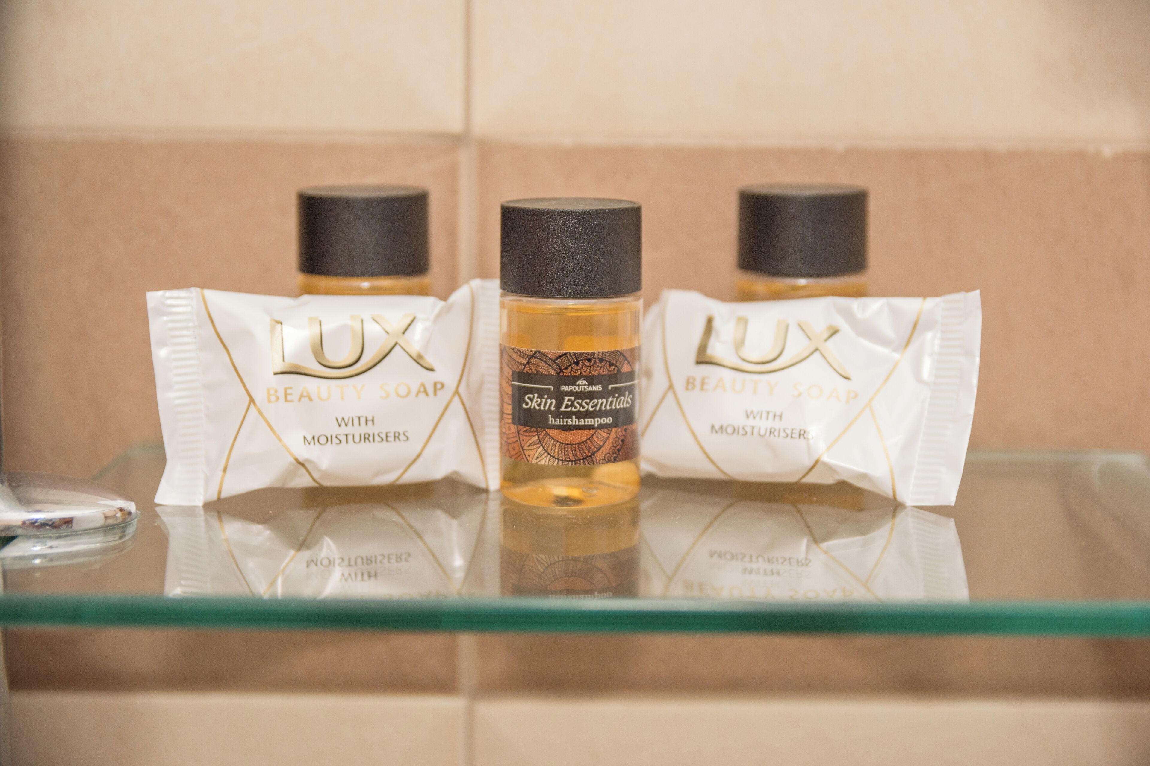 Three bottles of LUX Beauty Soap with moisturisers on a glass shelf.