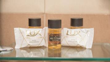 Three bottles of LUX Beauty Soap with moisturisers on a glass shelf.