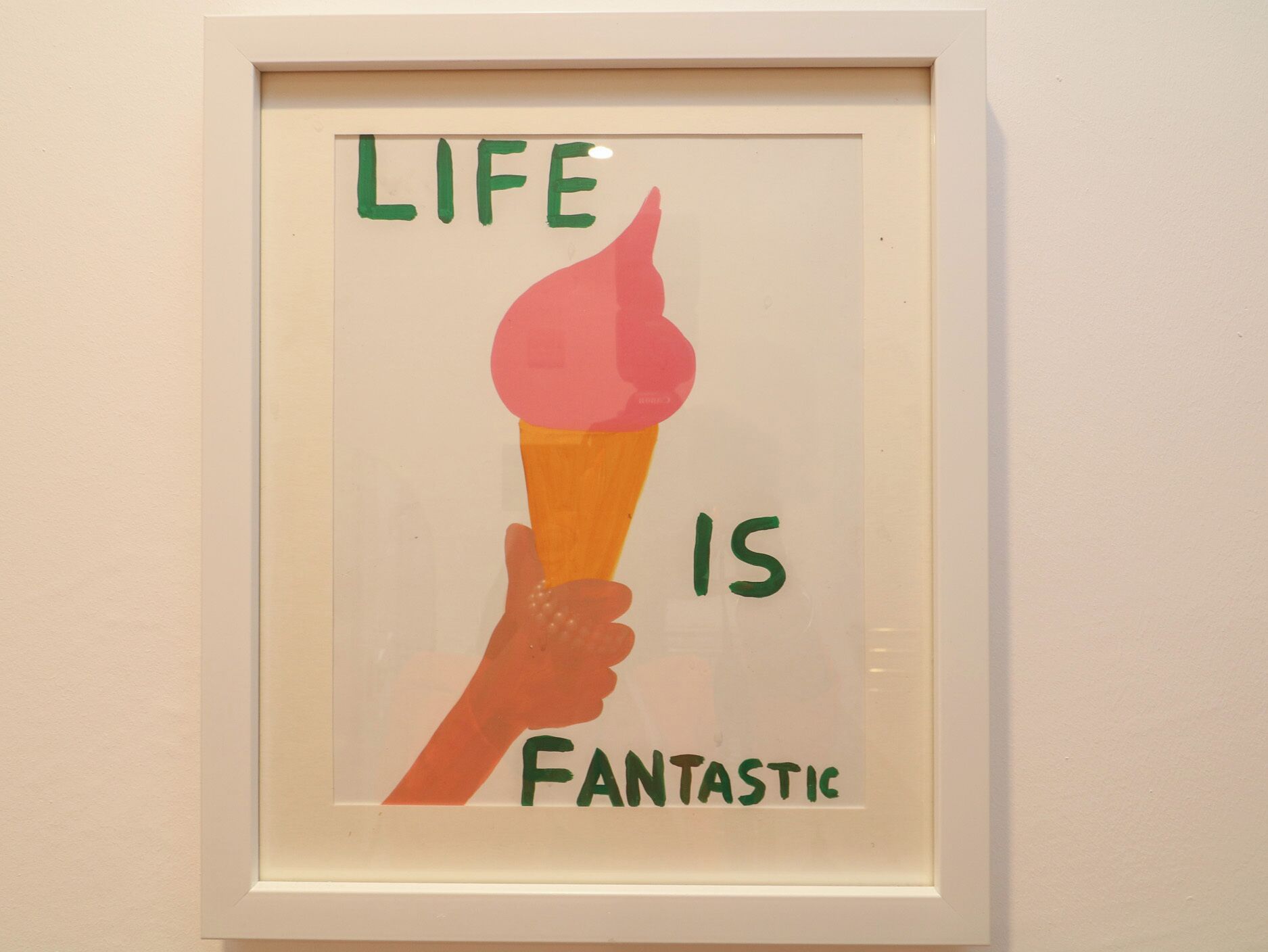 A framed artwork with a hand holding an ice cream cone and the text 'LIFE IS FANTASTIC'.