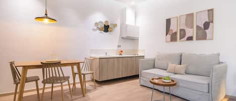 Ein stilvolles Wohnzimmer mit Essbereich, Küchenzeile und Sofa.