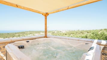 A hot tub with a view of a coastal landscape.
