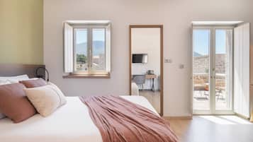 Une chambre à coucher avec un lit, un bureau et une vue sur l’extérieur.