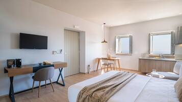 A modern hotel room with a bed, desk, chair, and a TV.