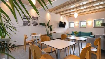 A modern interior with wooden furniture, a flat-screen TV, and a dining area.