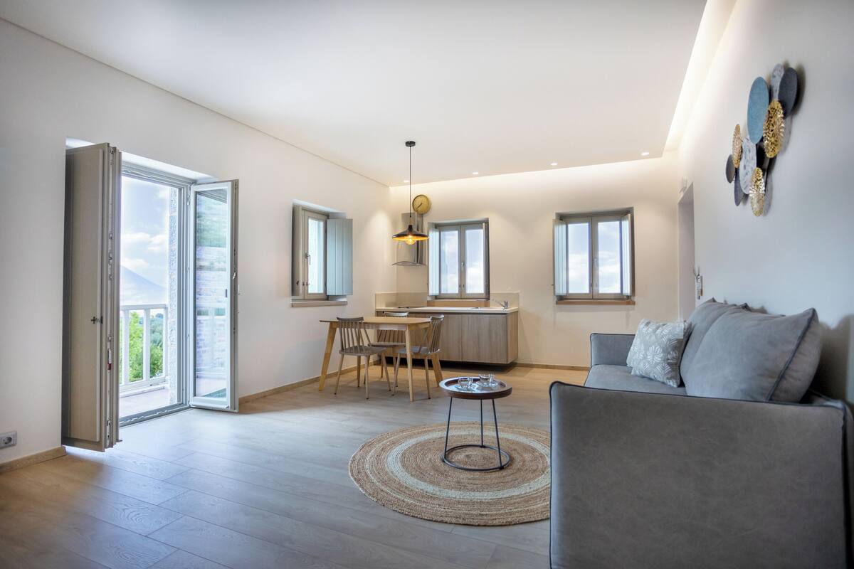 Un espacio de sala-comedor abierto con una mesa de comedor, un sofá y una cocina al fondo.