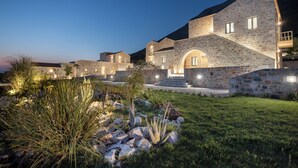 A stone building with multiple levels, a central staircase, and a well-lit entrance. - Armantanis Luxury Suites (Areopoli)