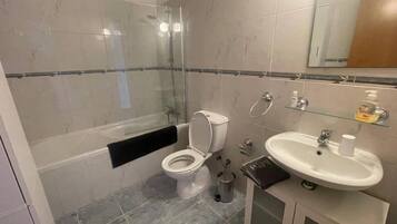 Kombinasi shower/bathtub, bathtub besar, dan handuk