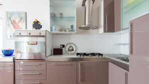 Uma cozinha moderna com eletrodomésticos de aço inoxidável, forno embutido e fogão a gás.