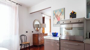 Uma cozinha com fogão, forno e uma tigela azul no balcão.