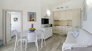 A compact living space with a dining area, kitchenette, and a cozy seating area. - Anita Bados by Interhome (Pittulongu)