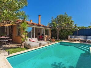 A poolside area with a covered seating area, a dining table, and a barbecue grill. - Miramar by Interhome (La Londe Les Maures)