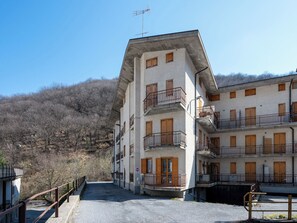 A multi-story building with balconies, a no-entry sign, and a view of a hilly landscape. - Ai piedi del Monte by Interhome (Frabosa Sottana)