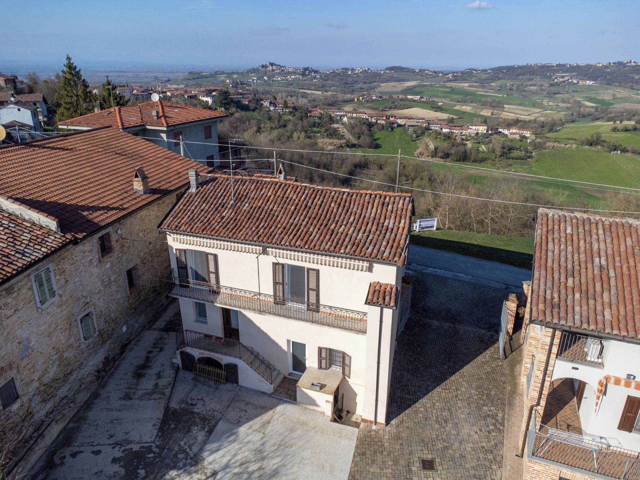 Un edificio con tetto in tegole, un balcone e vista sul paesaggio circostante.