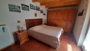 Un dormitorio con cabecera de madera, una cama, una mesita de noche y un armario.