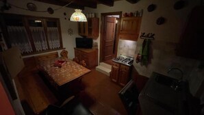 Una cocina funcional con armarios de madera, una mesa de comedor y una estufa.