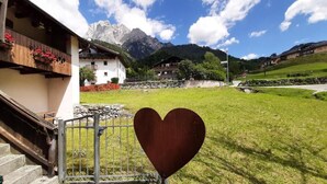 Un edificio con balcón, un letrero con forma de corazón y montañas al fondo.