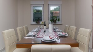 A dining table set for four with white chairs, a glass top, and a red and white table runner. - Holiday Home Vele With Pool (Vrgorac)