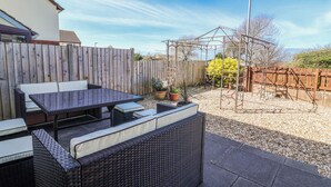 A patio with outdoor furniture, a wooden fence, and a metal pergola. - Sea Spray (Bideford)