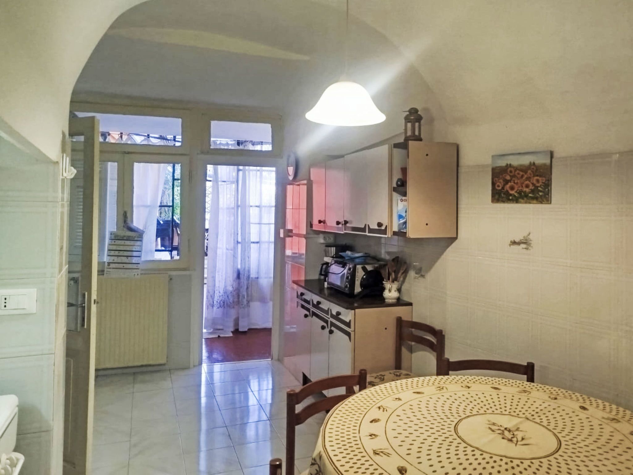 Una cocina con una mesa de comedor, sillas, estufa y armarios.
