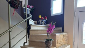 A staircase with a handrail, a potted plant, a lantern, and a radiator.