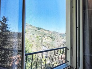 Ein Balkon mit Blick auf eine hügelige Landschaft.