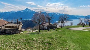 Ein malerischer Blick auf eine Berglandschaft mit einem See, einem Steinhaus und einem Holzzaun.