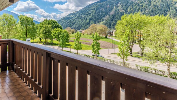 A balcony with a view of a mountain landscape, a road, and trees. - Campicioi by Interhome (Pinzolo)
