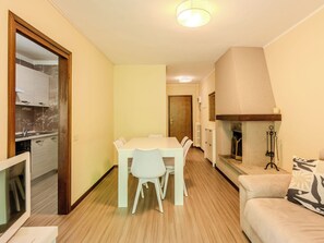 Ein gemütlicher Wohnbereich mit Essplatz, einer Couch, einem Kamin und einer Küche.