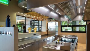 Een moderne keuken met roestvrijstalen apparatuur, een centraal kookeiland en decoratieve objecten op de vensterbank.