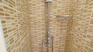 A shower with a rain showerhead, handheld showerhead, and a wall-mounted control.