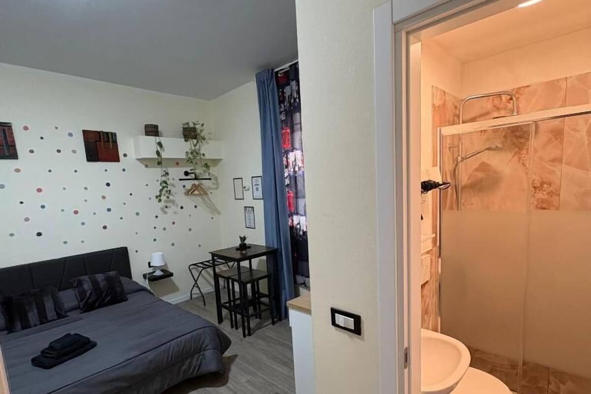 Ein Schlafzimmer mit einem Bett, einem Nachttisch und einem kleinen Schreibtisch mit Stuhl.
